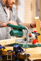 Man sawing wood with a circular saw on a workbench