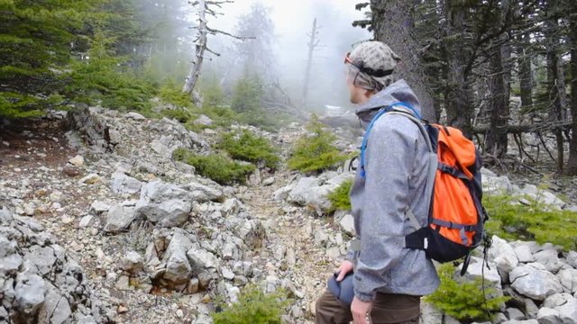 Hiker walking outdoors wearing hiker backpacks.