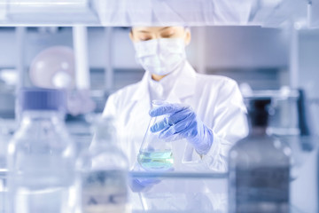 Fototapeta premium Female scientist looking at the sample in laboratory