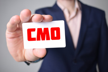 Businessman shows business card with the inscription:CMO