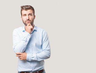 young confused and handsome man, blue t shirt, thinking or worried expression . person isolated...