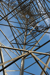 Electric power pylon shapes close up against a blue sky