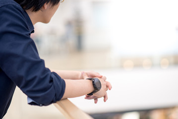 Young asian man leaning arm on railing in shopping mall. Urban lifestyle concept