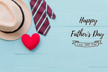 Happy fathers day concept. Red tie, man hat and handmade red heart on bright blue pastel wooden table background.