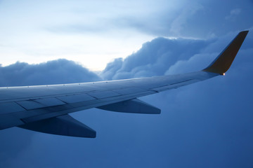 Wing passenger aircraft in flight over the evening clouds