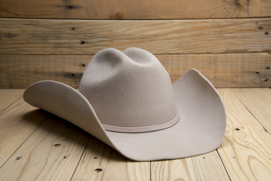Western cowboy hat made of fur on wooden background.