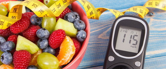 Fruit salad, glucose meter for measuring sugar level and centimeter, healthy lifestyle and...