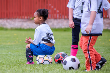 Obraz premium A young girl is learning how to play soccer 