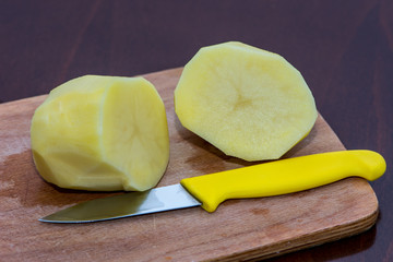 Peeled potatos on the wooden board