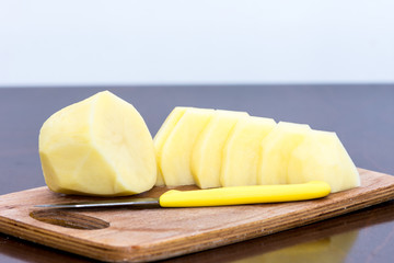 Peeled potatos on the wooden board