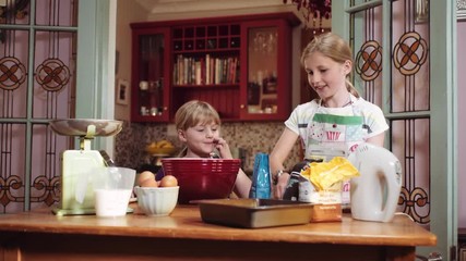 Slider shot of two sisters checking the cookbook before adding the ingredients to bake a cake in the kitchen.