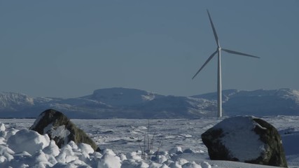 Windmills in winter landscape. Various windmills beautifully framed against snow covered moors, rolling hills and peaks in a frosty winter landscape on a bright sunny winter day in Norway