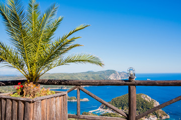View on the bay and beach Paleokastritsa with flowers, palm tree and blue sea water on the Island Corfu, Greece.View point in Lakones. Copy space