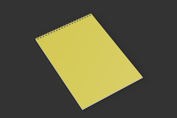 Blank yellow notebook with metal spiral bound on black background