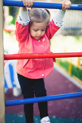 Obraz premium Climbing little girl at playground. Playground outdoor in summer time