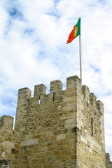 Portuguese flag waving on tower of Sao Jorge Castle. Lisbon, Portugal