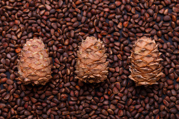 Pine nuts in shells as a background Three hole cedar cones Copy space Top view