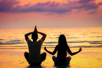 yoga or meditation concept background, silhouette loving couple people on the beach at sunset