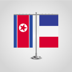 Table stand with flags of North Korea and France.Two flag. Flag pole. Symbolizing the cooperation between the two countries. Table flags