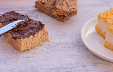 Breakfast chose, slice of bread whit nougat cream, integral stick bread, creamy cheese cookies and fresh glass of milk/ starting a day/ food background