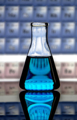 laboratory glassware , a conical flask containing blue liquid on a reflecting surface