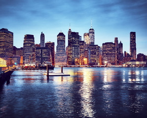 Manhattan skyline reflected in East River at dusk, color toned picture, New York City, USA.
