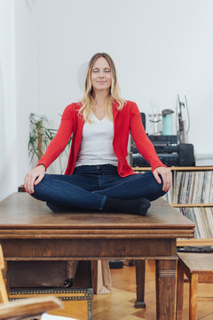 Serene young woman meditating at home