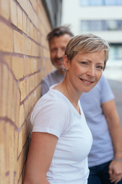 Smiling mature woman leaning against wall