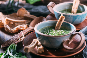 soup of puree, chowder from spinach in beautiful tableware on a wooden table