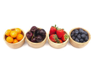Fresh summer fruits, Cherry, strawberry, cape gooseberry and blueberry in wooden bowl isolated on white background.