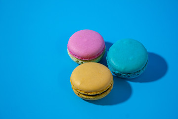 Macarons on cyan background top view right position.