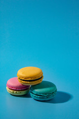 Macarons on cyan background vertical.