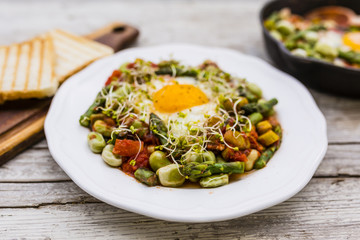 Fried shakshouka with seasonal vegetables asparagus and broad bean. 