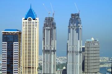 Tall skyscrapers in Dubai Business Bay with beautiful blue sky in background.