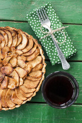 Juicy apple pie with cinnamon and brandy on a green background