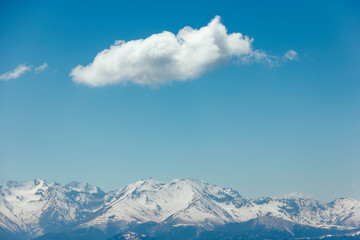 Fototapeta na wymiar Mountains with peaks covered with snow, white clouds on blue sky, Caucasus