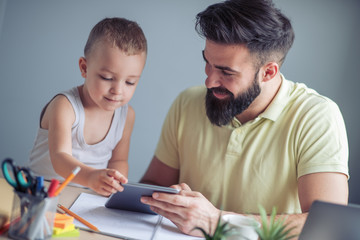 Man working from home and playing with his son