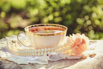 Porcelain cup of tea in the summer garden. Tea in the garden. Evening tea