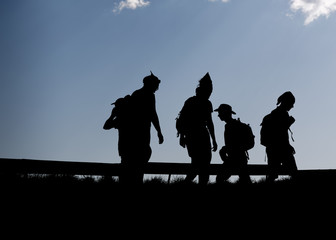 Obraz premium Hikers silhouettes thru thetop of the mountain over blue sky background 