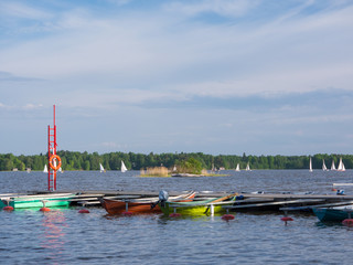 Obraz premium Sailing competition and small boats in marina on sunny lake