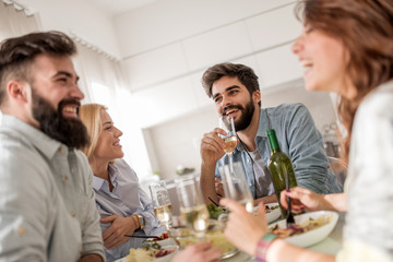 Positive happy young people enjoying food at home