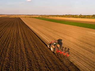 Aerial shot of a farmer plowing stubble field