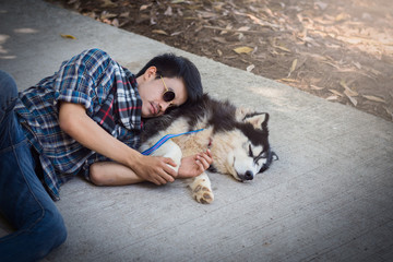 Siberian husky dog sleep on a cement floor with the owner.