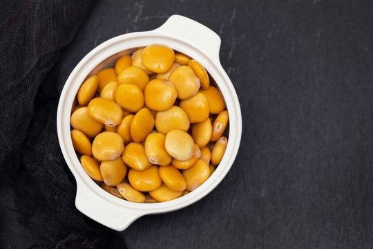 salted lupins in white bowl on black ceramic background