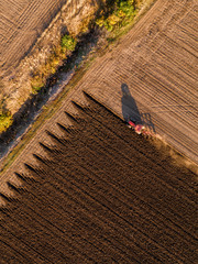 Aerial shot of a farmer plowing stubble field © oticki