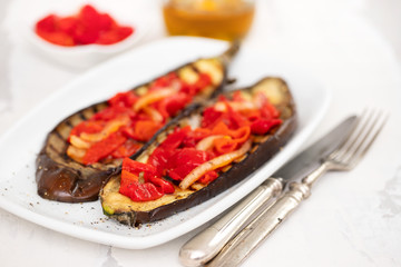 grilled eggplant with red pepper on white dish