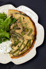 omelette with asparagus, fresh salad and sauce on white dish