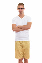 Fototapeta premium Young handsome man standing while wearing eyeglasses with arms c
