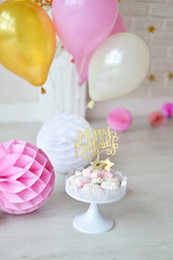 One year birthday decorations. Decorations for holiday party. A lot of balloons pink and white colors. Cake for birthday party. 