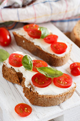 Bruschetta with cream cheese, cherry tomatoes and basil